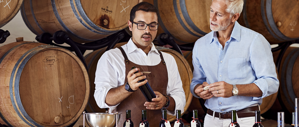 Un professionnel du vin chez VINIV explique à un participant l'assemblage de vin.