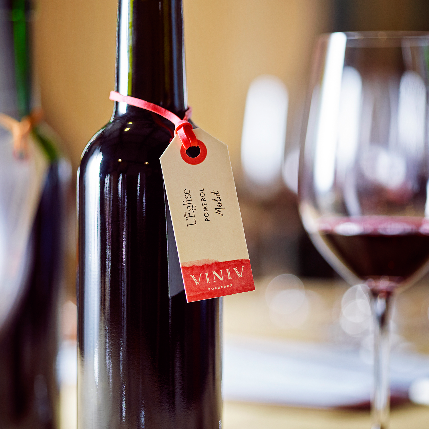 Bouteille de vin avec une étiquette accrochée autour du goulot suite à un atelier assemblage.